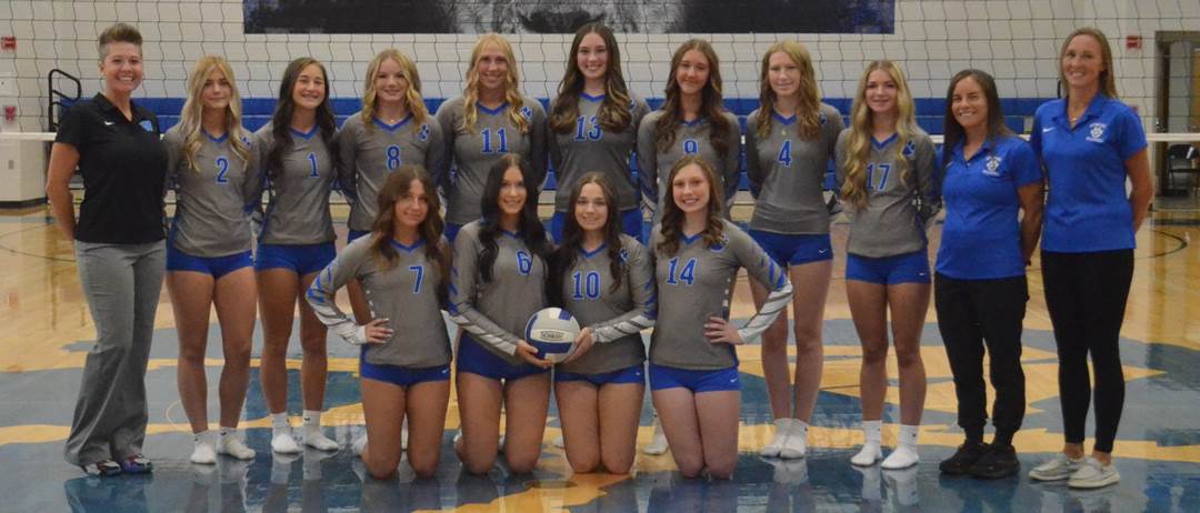 A group of girls in matching uniforms posing for a photo

Description automatically generated